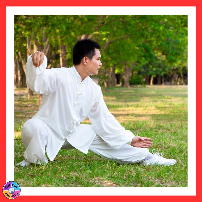 Image of a man doing taiji or another martial art; he is wearing a white uniform and is doing it outside on grass.